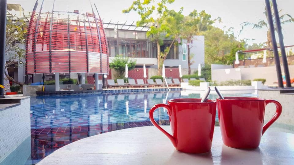 foto di due tazze rosse con sfondo su una piscina