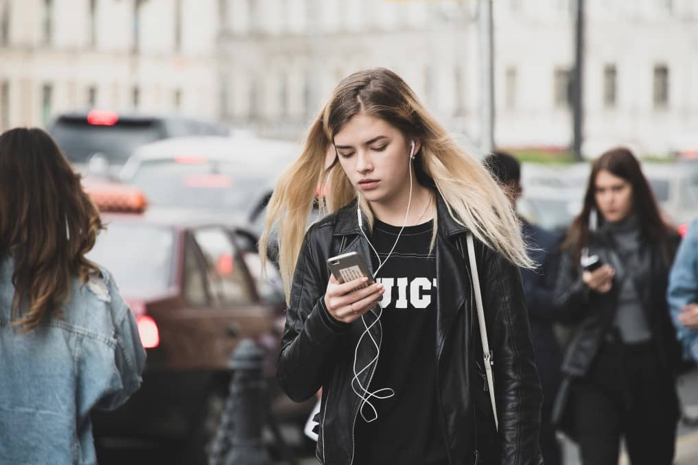 ragazza che cammina in strada ascoltando musica