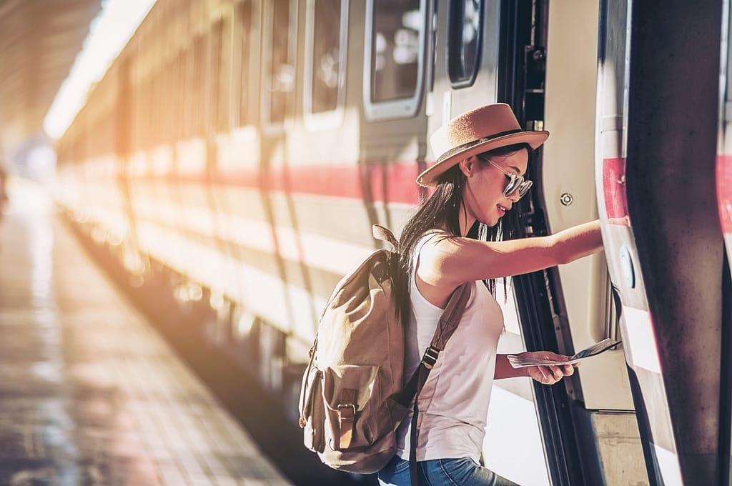Donna turista che guarda la mappa mentre cammina alla stazione ferroviaria