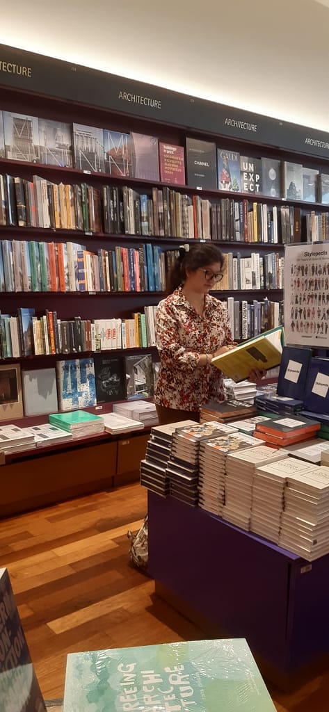 ragazza in libreria che legge un libro