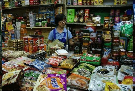 Signora thailandese dietro la sua bancarella al mercato Gimyong di Hatyai