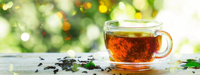 Tazza di tè con sfondo verde, forse foglie, sfocato