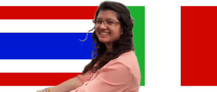 foto di una ragazza con dietro di sé due bandiere: quella thailandese e quella italiana