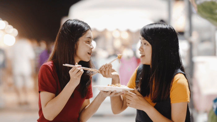 due ragazze thailandesi che mangiano dello street food