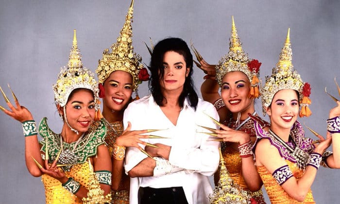 Foto dal set del video musicale Black or White di Michael Jackson in posa al centro con 4 ragazze thailandesi, che indossano i copricapi e vestiti thailandesi tipici