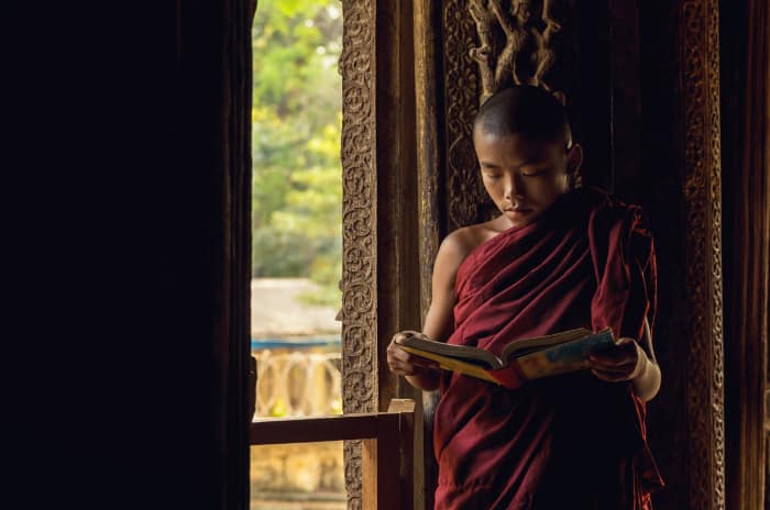 Closeup Buddhist novice reading at Shwenandaw pagoda, mandalay,