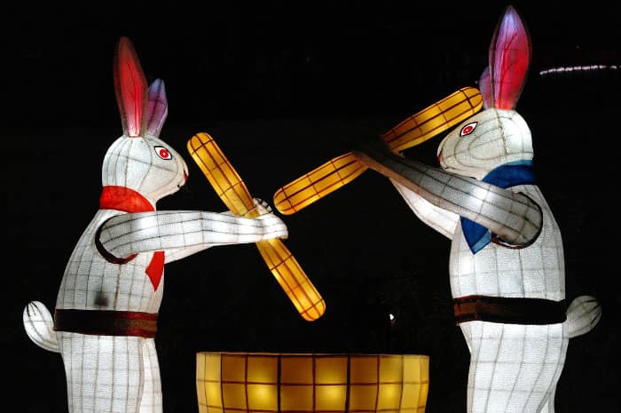 sculture luminose a forma di conigli che  pestano in un mortaio