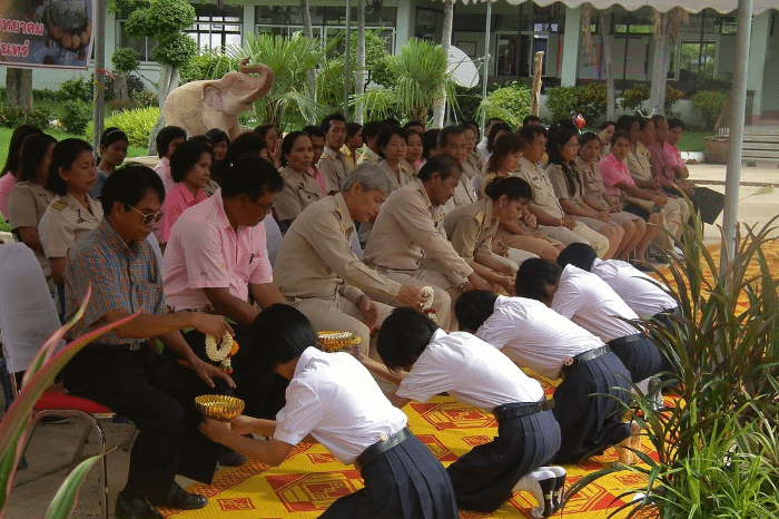 Alunni con divisa scolastica thailandese che si inchinano di fronte ai propri insegnanti durante la cerimonia della festa degli insegnanti in Thailandia