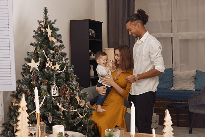 famiglia multietnica che prepara l'albero di natale