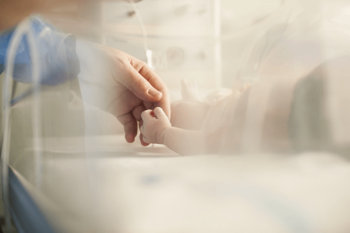 mano di un uomo che tiene la mano di un neonato