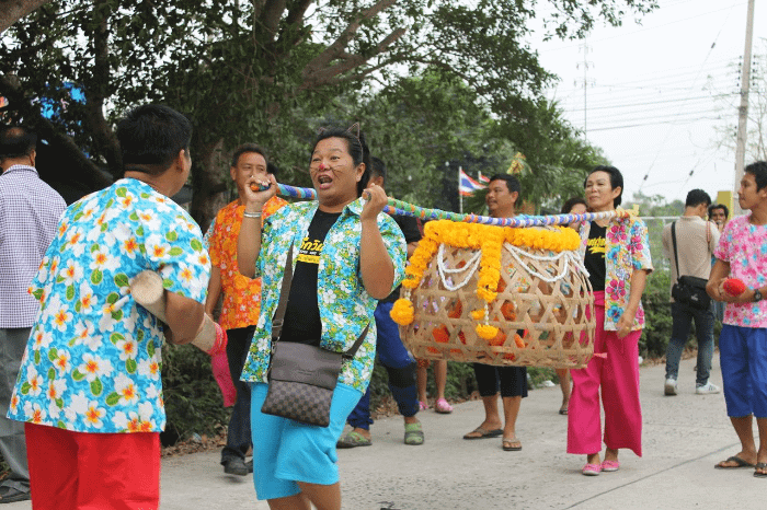 processione di thailandesi con cesta al cui interno c'è un gatto; rito per far piovere
