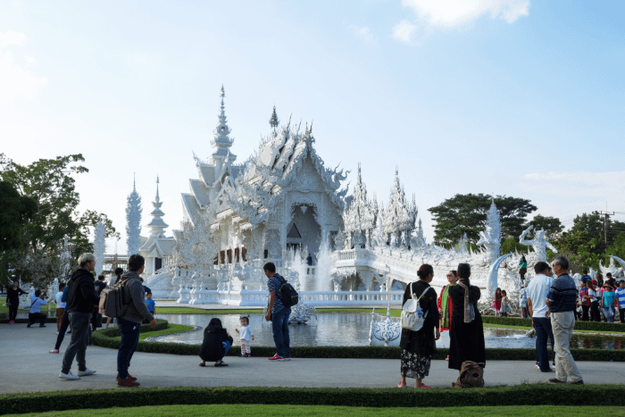 Esterno del tempio bianco di Chiang Rai - vista con persone in primo piano