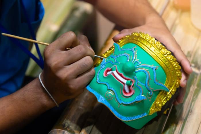 artista thailandese che pittura una maschera di uno yak per uno spettacolo di danza tradizionale thailandese