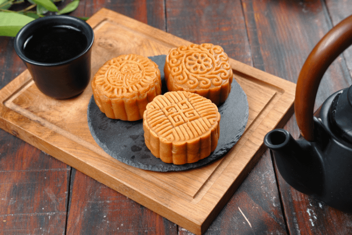 tre dolcetti mooncake tipici cinesi, con differenti decorazioni sulla parte superiore