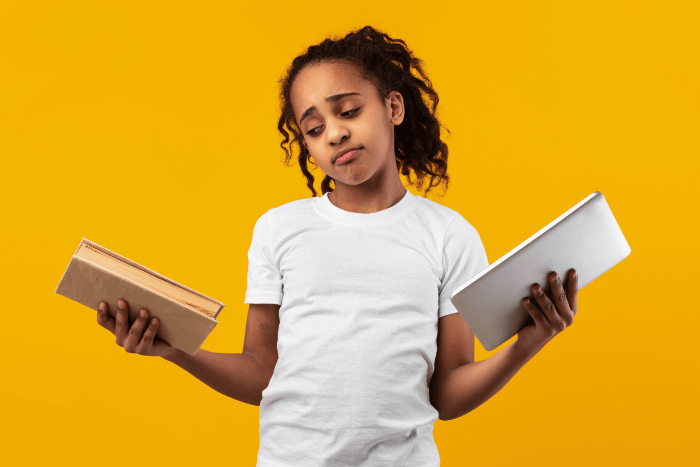 ragazza dubbiosa con in mano un libro e un tablet