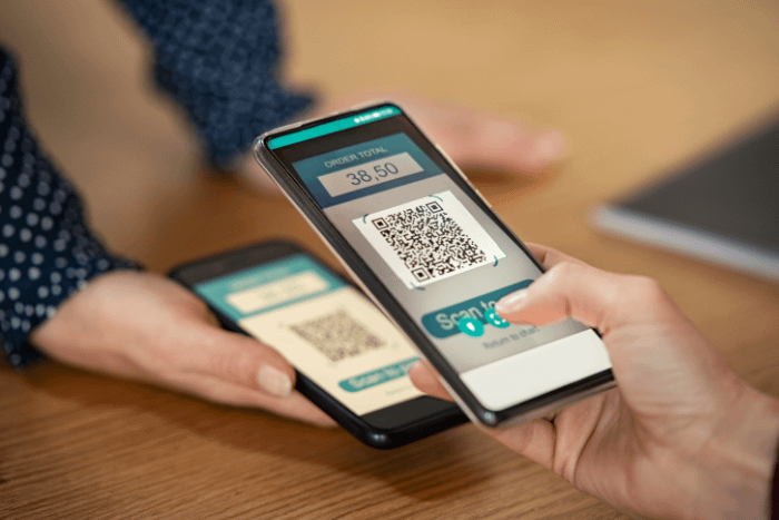donna che scansiona codice per pagare tramite app cellulare