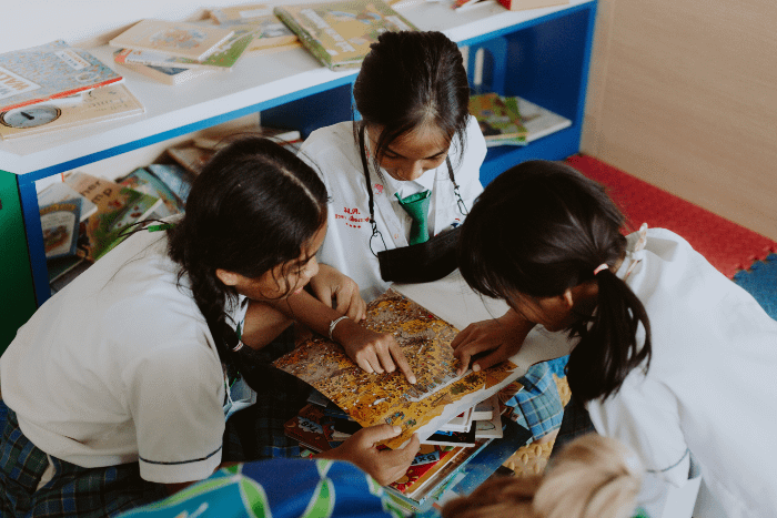 bambine thailandesi che guardano insieme un libro illustrato