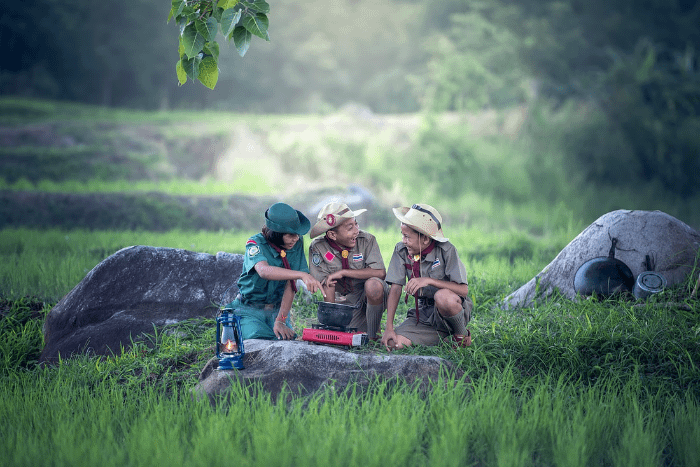 tre bambini thailandesi vestiti come scout nella natura