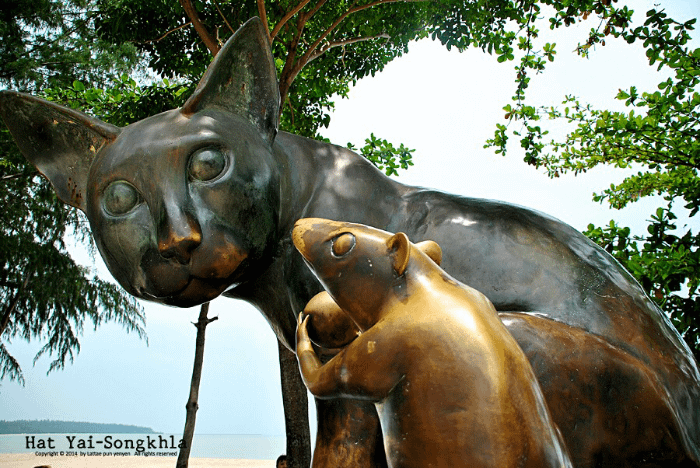 foto ravvicinata delle statue del gatto e del topo con la sfera in mano