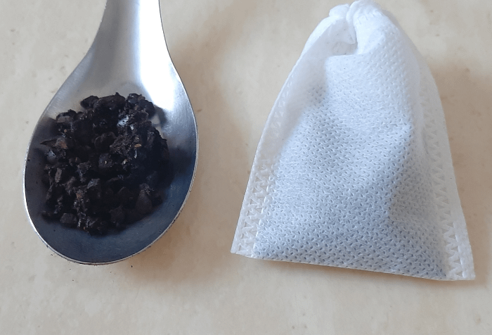 grani di caffè sfusi e bustina con grani di caffè al suo interno