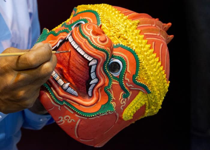 artista thailandese che pittura una maschera di uno yak per uno spettacolo di danza tradizionale thailandese