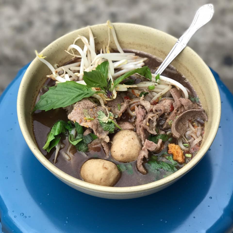 primo piano di un piatto di nam tok noodles thai