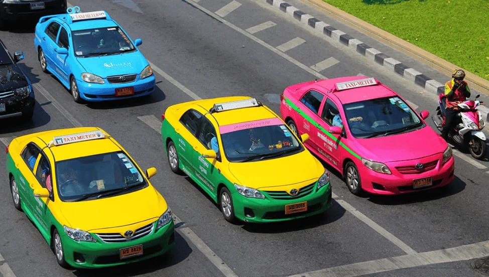 taxi colorati allineati al semaforo a Bangkok